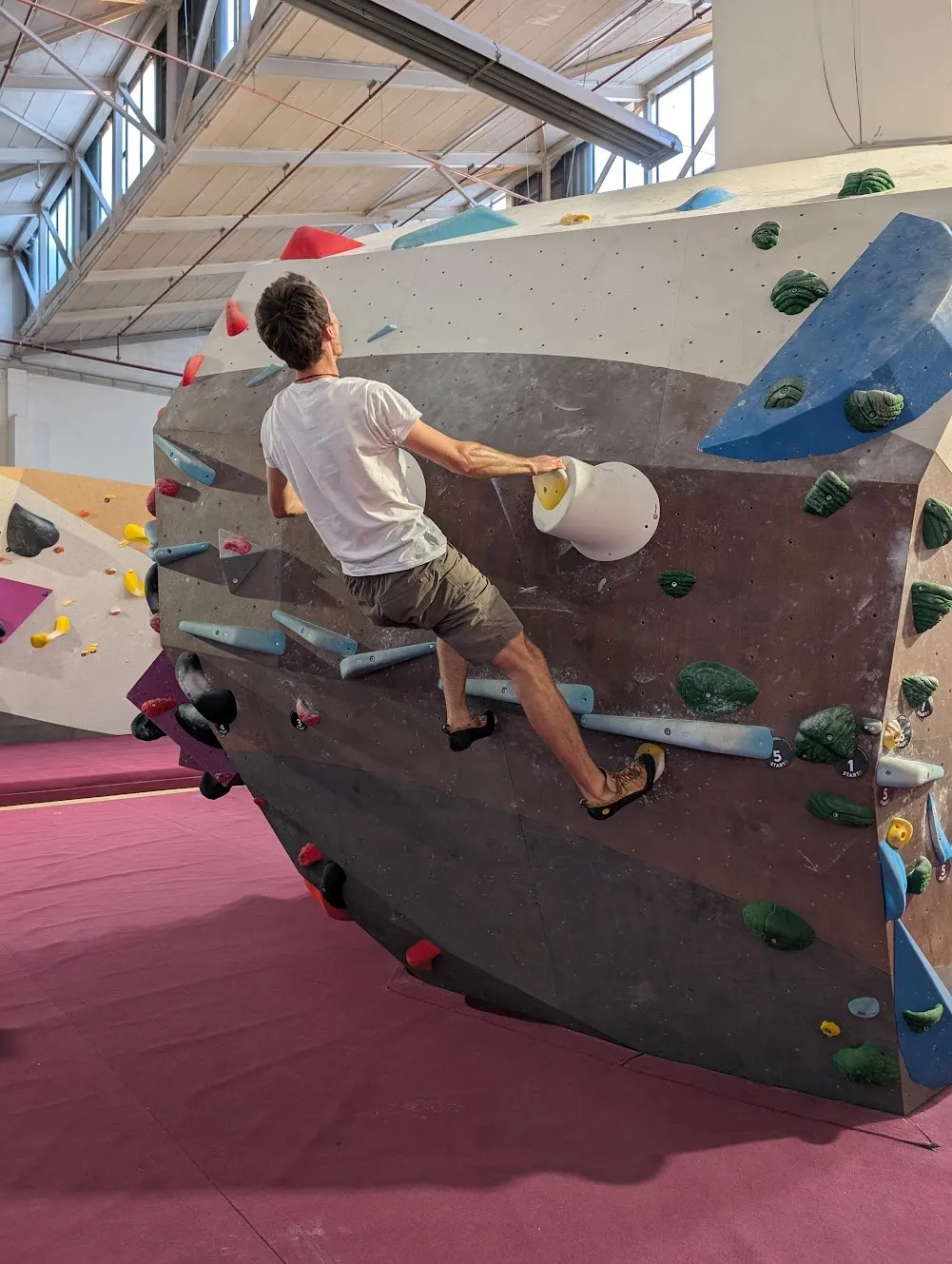 A colleague climbing a wall in a bouldering gym